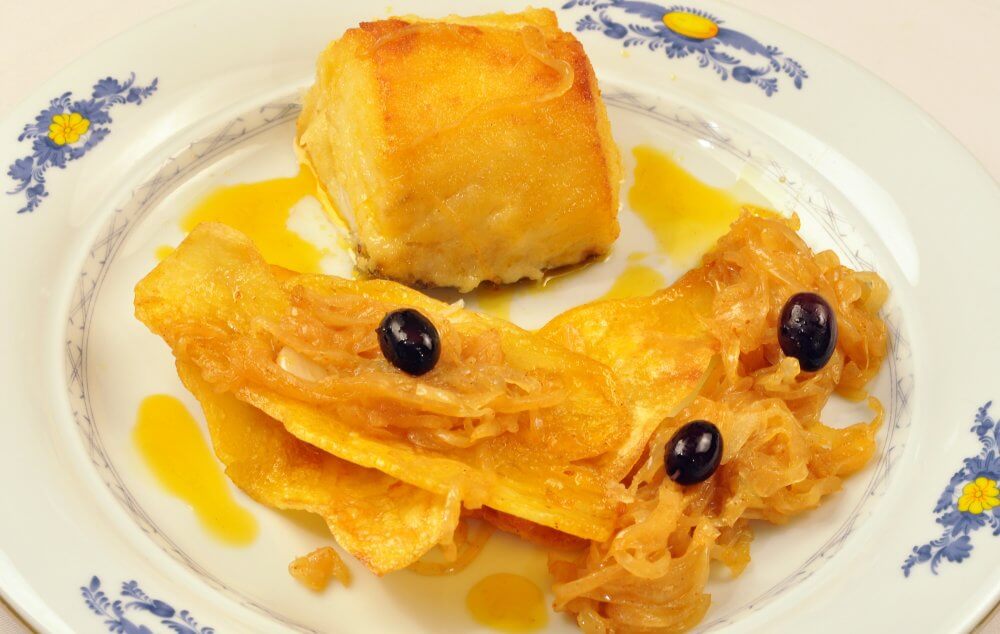 Posta de Bacalhau assada puxada na cebola e páprica, azeite, batata frita a portuguesa e arroz.